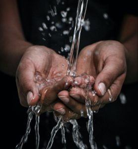 A stream of water hitting a pair of cupped hands